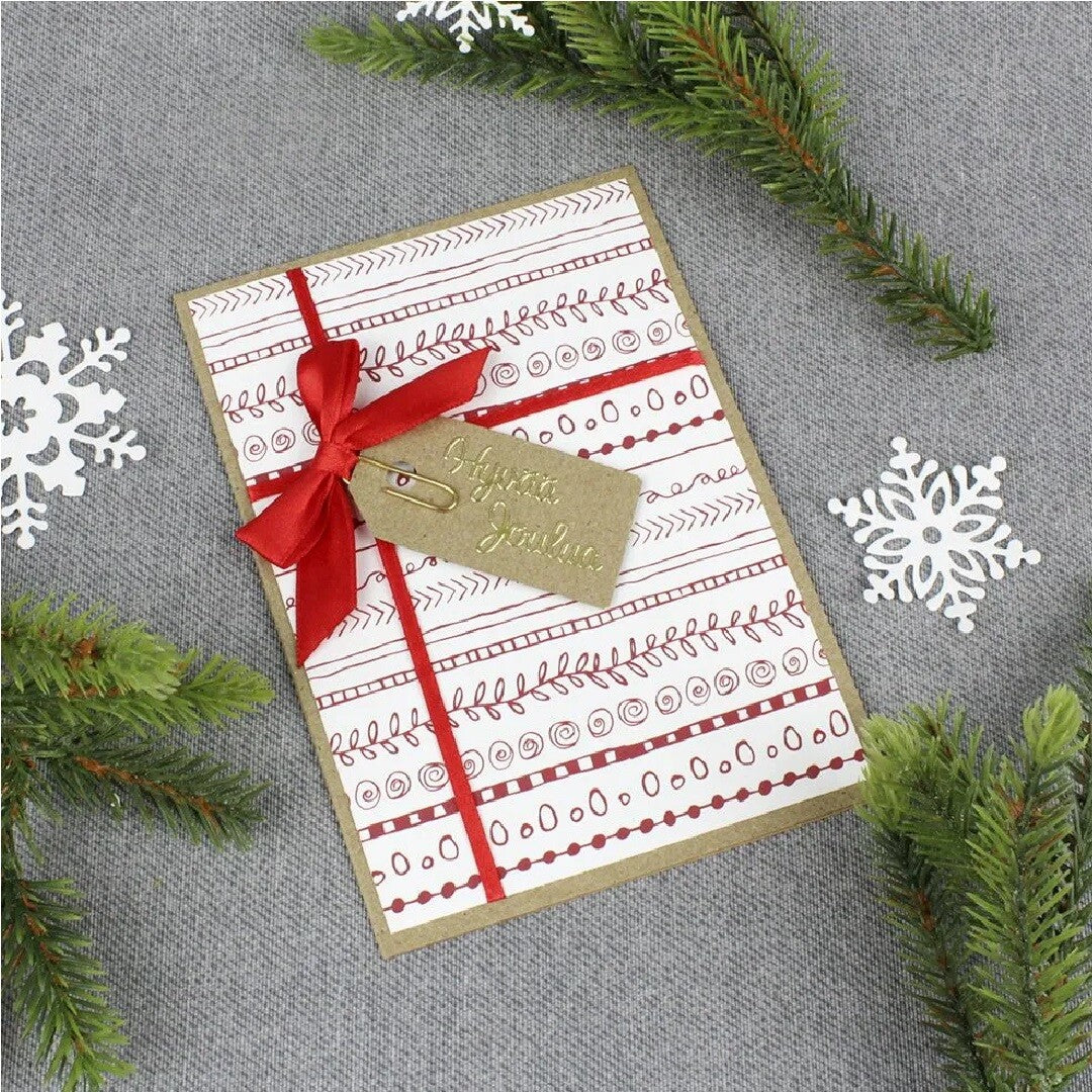Een naturel cadeaulabel met kersttekst bevestigd aan een kerstkaart met rode strik.