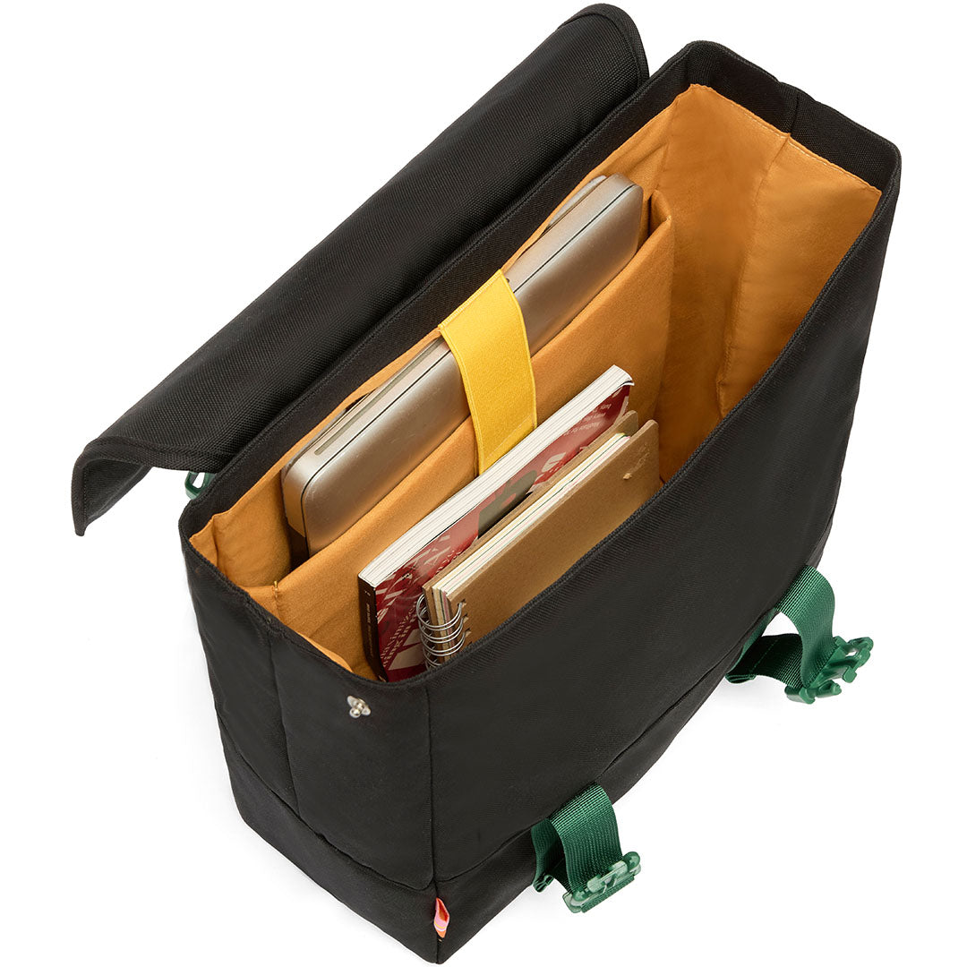 De open binnenkant van de zwarte schoolrugzak met een geel laptopvak en notitieboeken.
