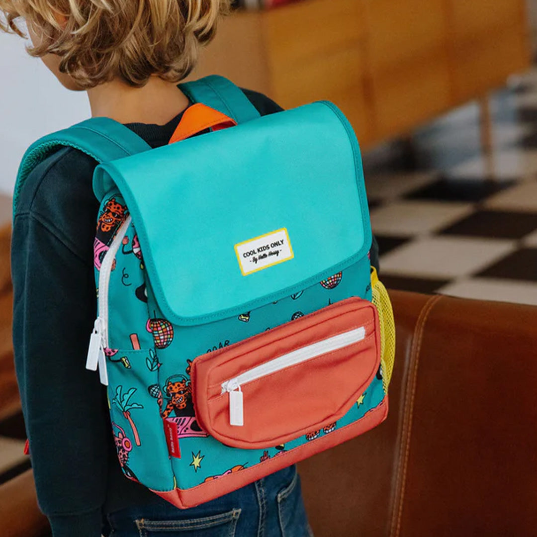 Kind draagt de Hello Hossy schoolrugzak met disco roar patroon op de rug.