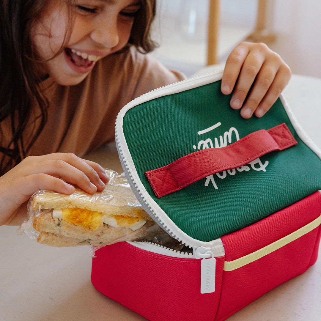 Een kind opent de Hello Hossy mini lunchtas om een sandwich erin te plaatsen.