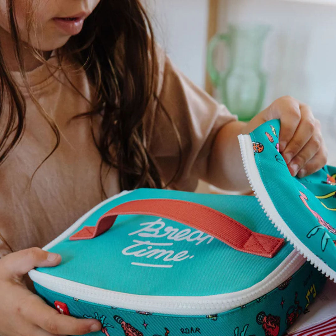 Een kind opent de hello hossy groene snacktas met disco roar patroon verder.