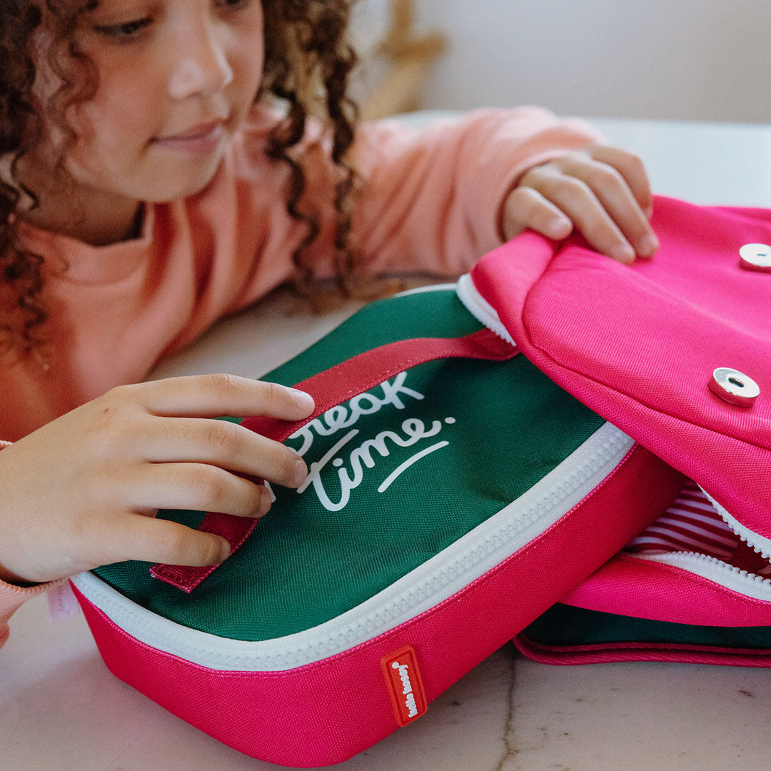 Een kind houdt de hello hossy snacktas met "Break Time" tekst vast, met een andere roze tas op de achtergrond.