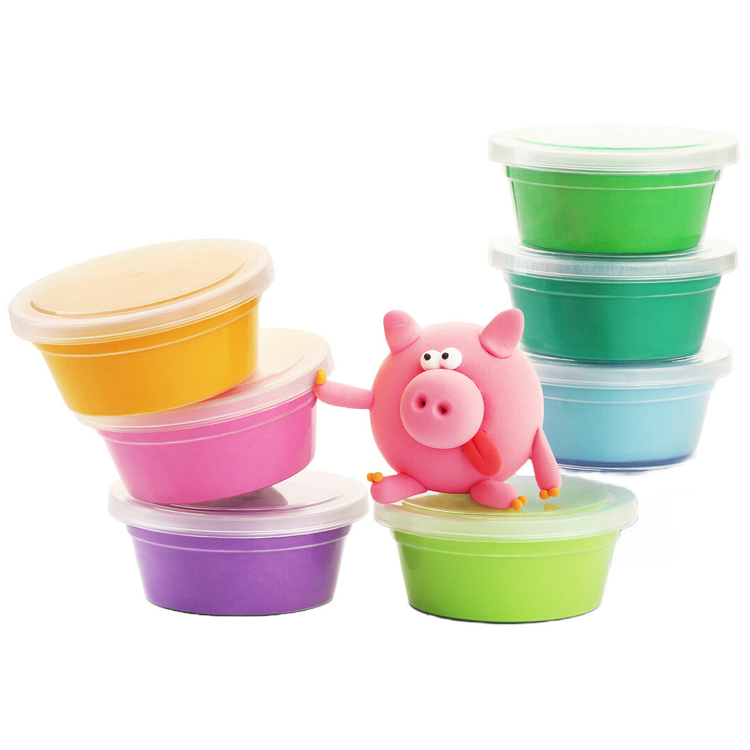 Een roze Hey Clay boetseerklei varken zit op een groene pot klei, omringd door andere kleurrijke kleipotten.