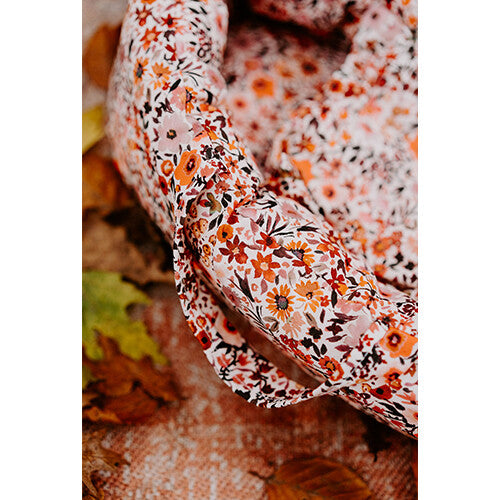 Detail van de hollie poppenreiswieg met retro bloemenpatroon en een handvat.