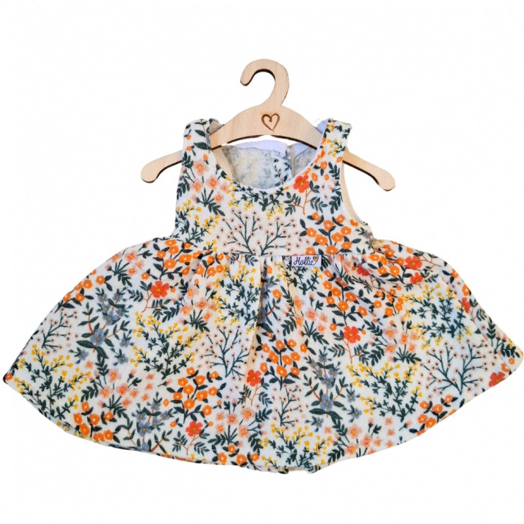 Hollie poppenkleding jurk met gebloemd 'summer flower garden' patroon, hangend aan een houten hanger.