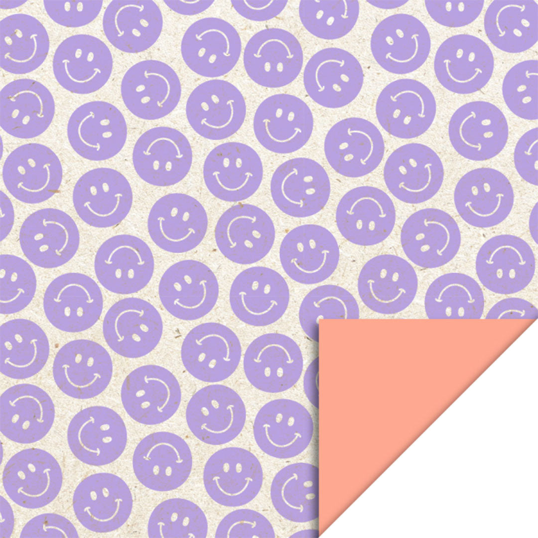 house of products inpakpapier met paarse smileys en een omgevouwen hoek die de zalmkleurige achterkant toont.