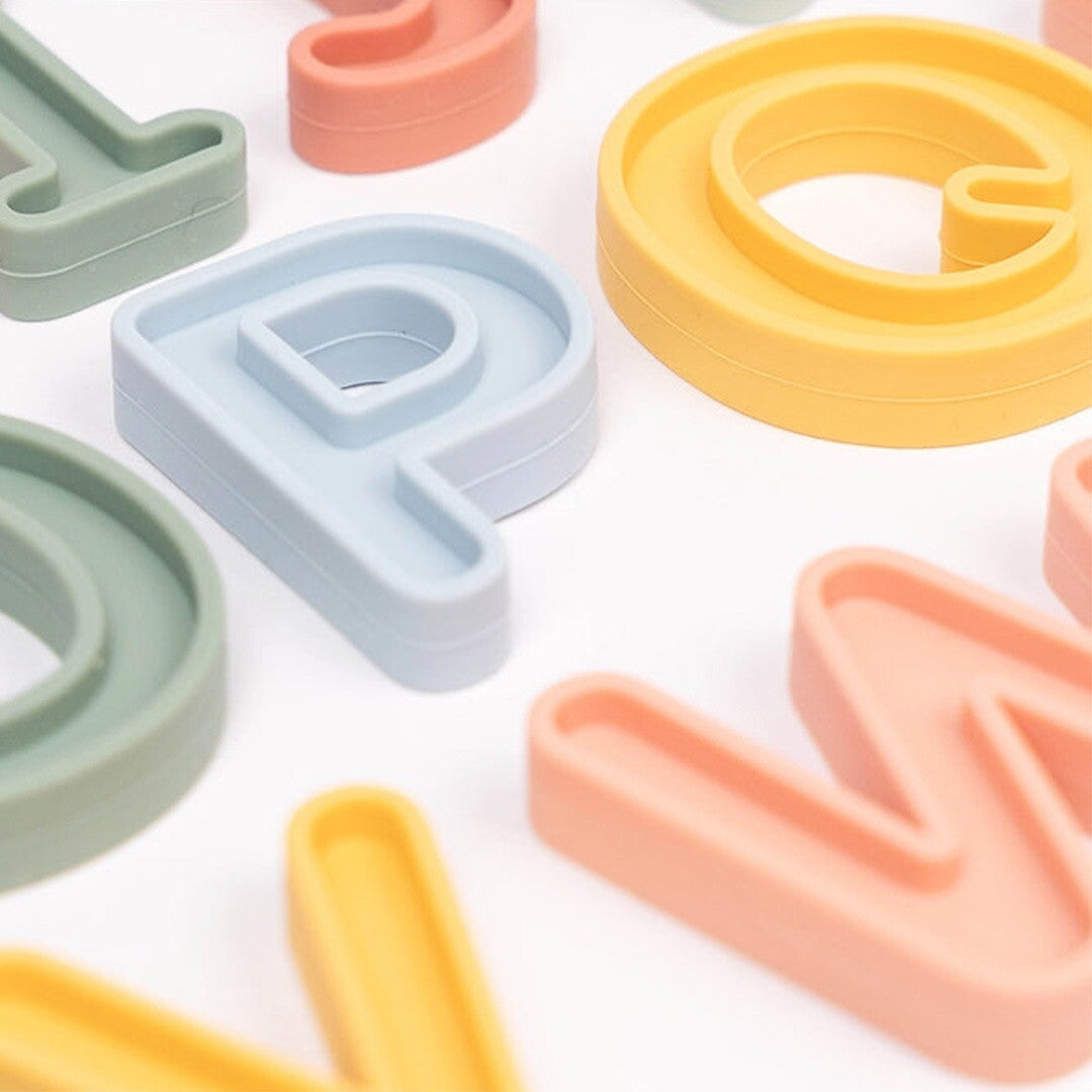 Detailopname van diverse inspire my play siliconen alfabet hoofdletters in pastelkleuren.