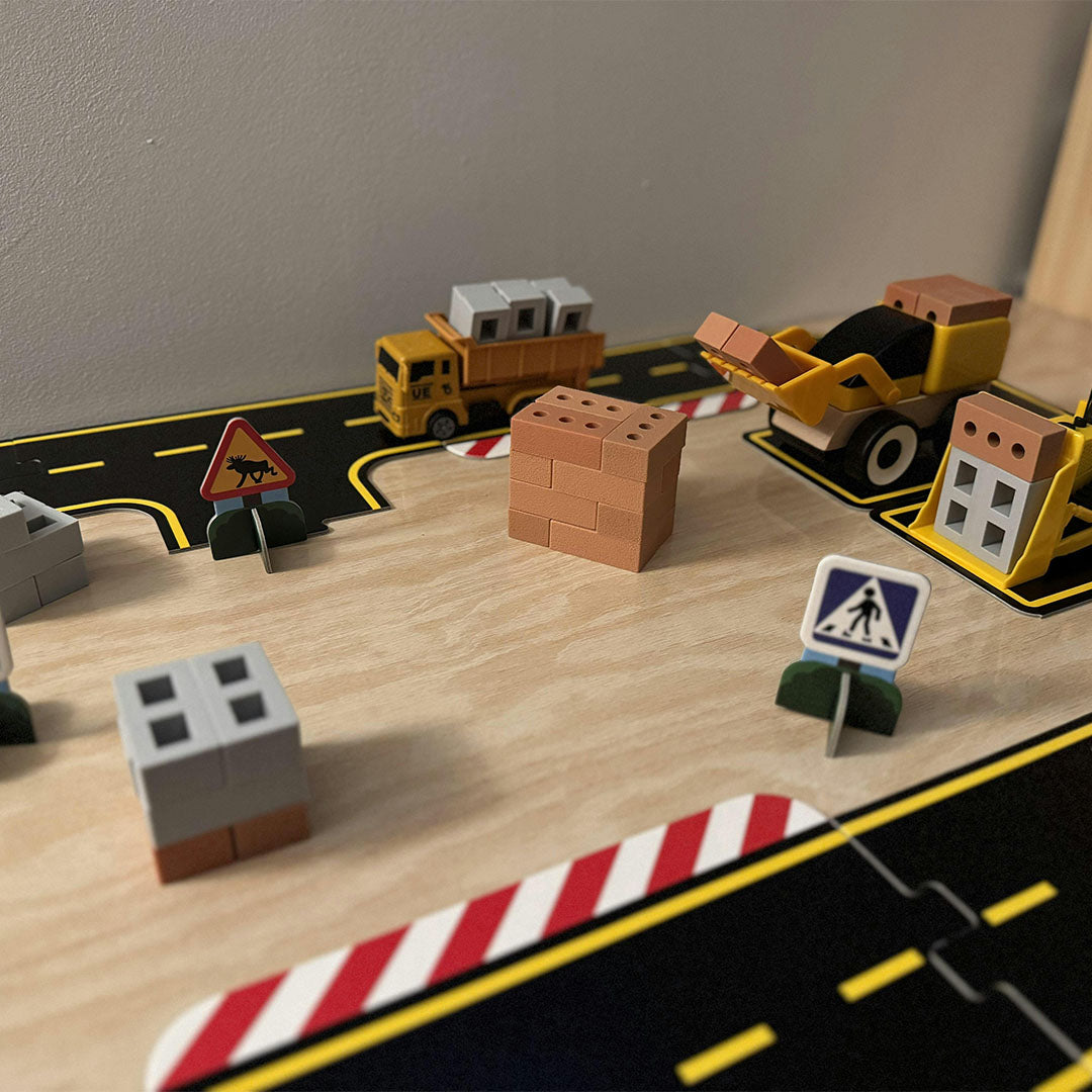 inspire my play bouwset met mini blokken, speelgoedvrachtwagens en verkeersborden op een speelmat met wegen.