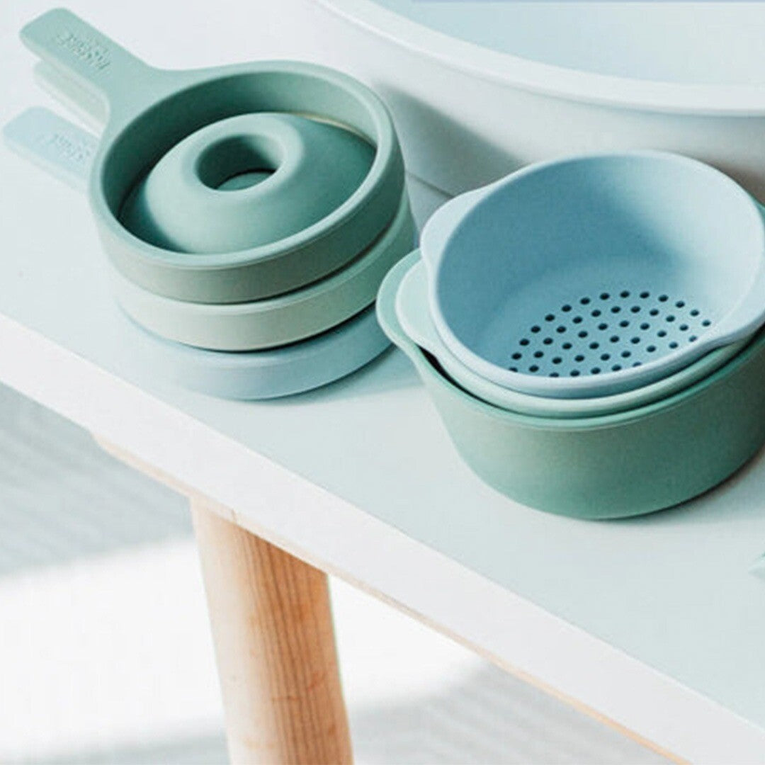 Een collectie inspire my play siliconen sensorisch speelgoed met opvouwbare trechters en kommen in blauw en groen.