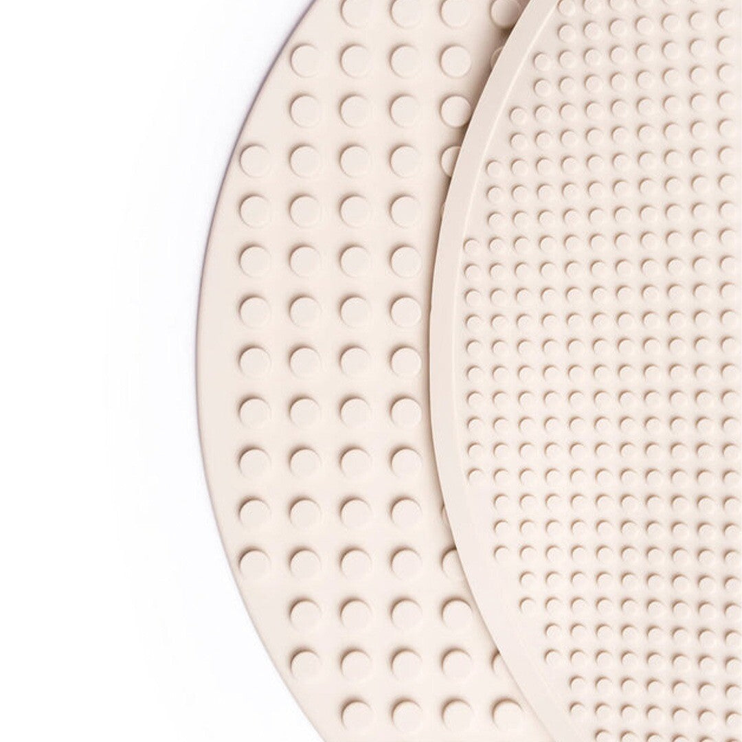 Twee beige, halfronde siliconen bouwmatten met noppen, van bovenaf gezien.
