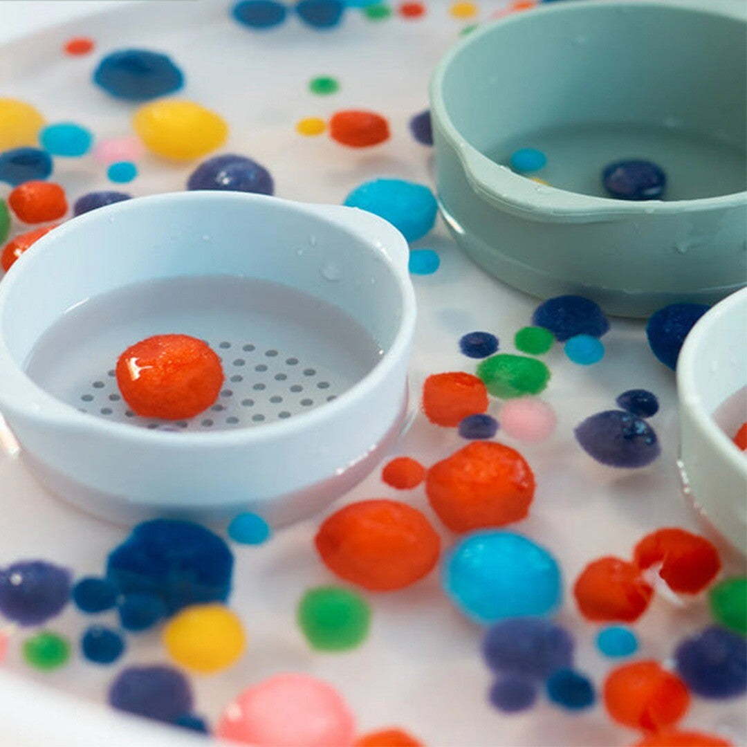 Twee inspire my play sorteerbakjes in water met kleurrijke waterparels, gebruikt als sensorisch speelgoed.