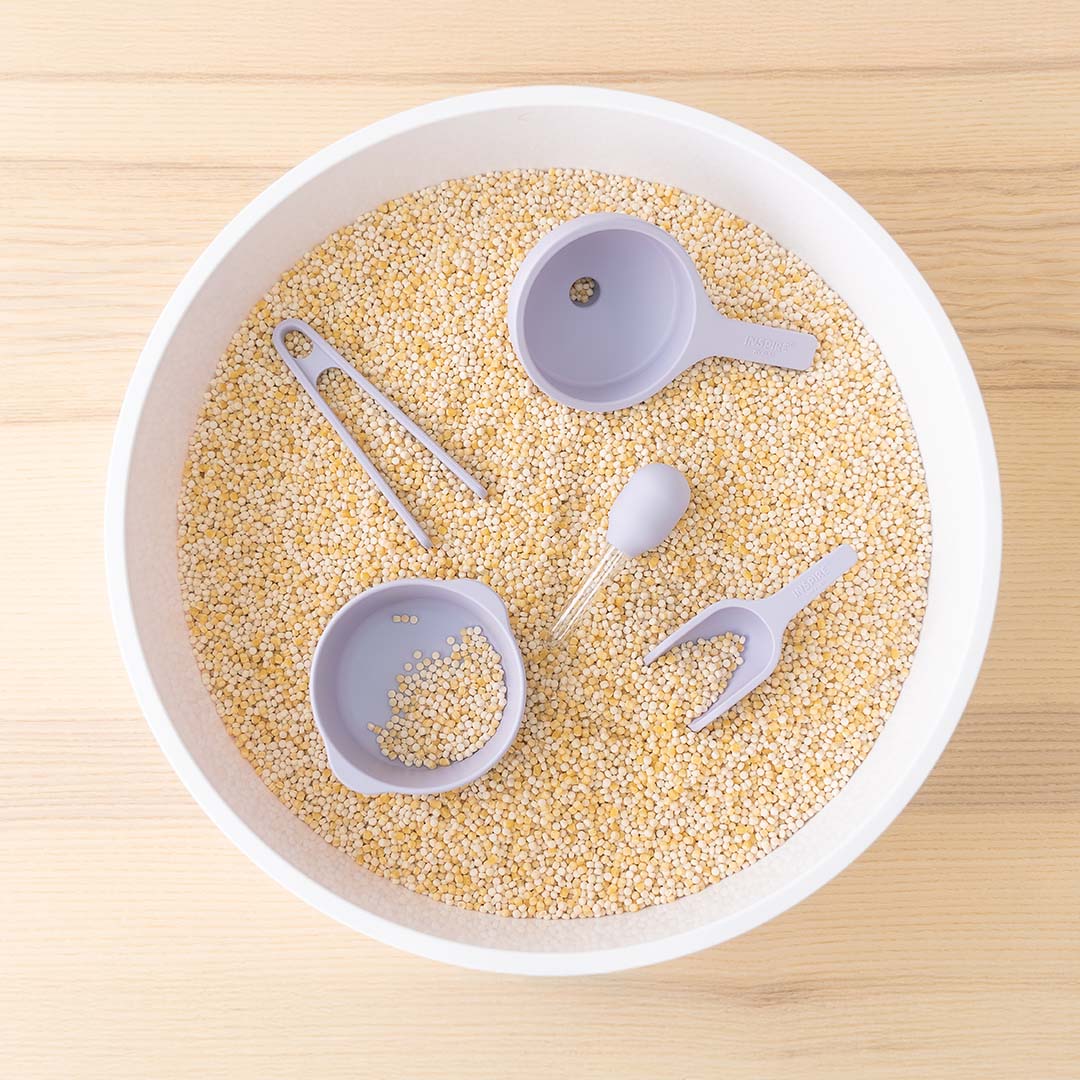 De lila inspire my play starter tool set in een witte bak gevuld met kleine korrels.