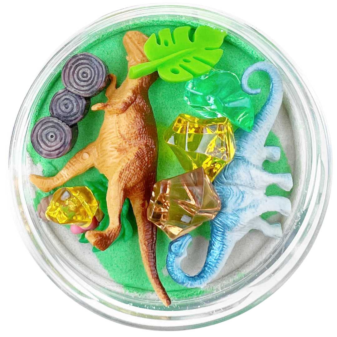 Invitation to imagine magic sand verrassingspot met twee dinosaurussen, bladeren, edelstenen en boomstammen in groen en wit zand.