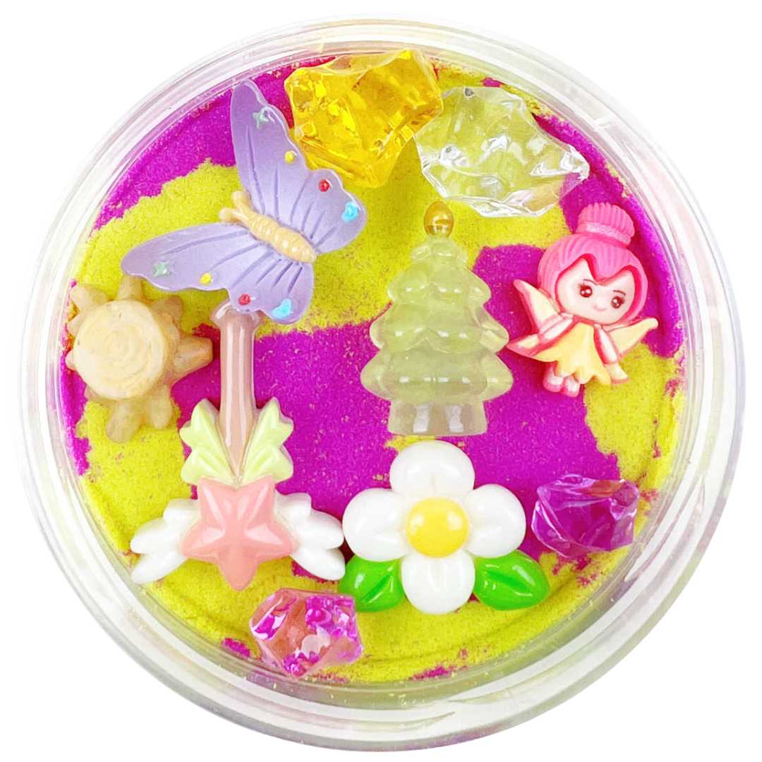 Invitation to Imagine magic sand surprise pot met roze en geel zand en diverse kleine figuurtjes zoals een vlinder, een elfje, een boom en bloemen.