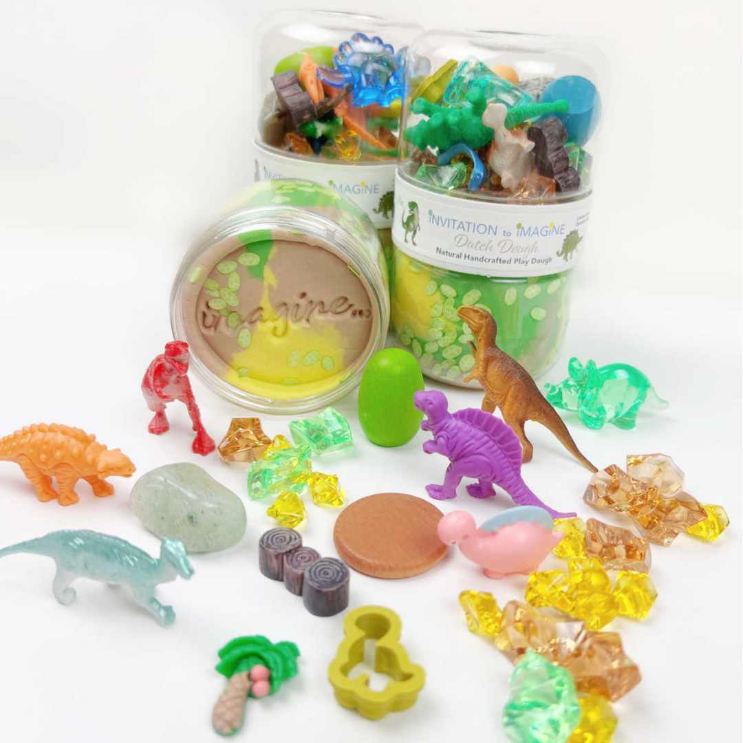 Diverse dinosaurus speelgoedfiguren en accessoires uit de invitation to imagine speelklei set, uitgestald op een witte ondergrond.