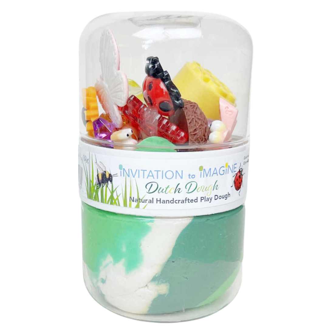 invitation to imagine speelklei play pot met groene en witte klei en tuin-thema accessoires.