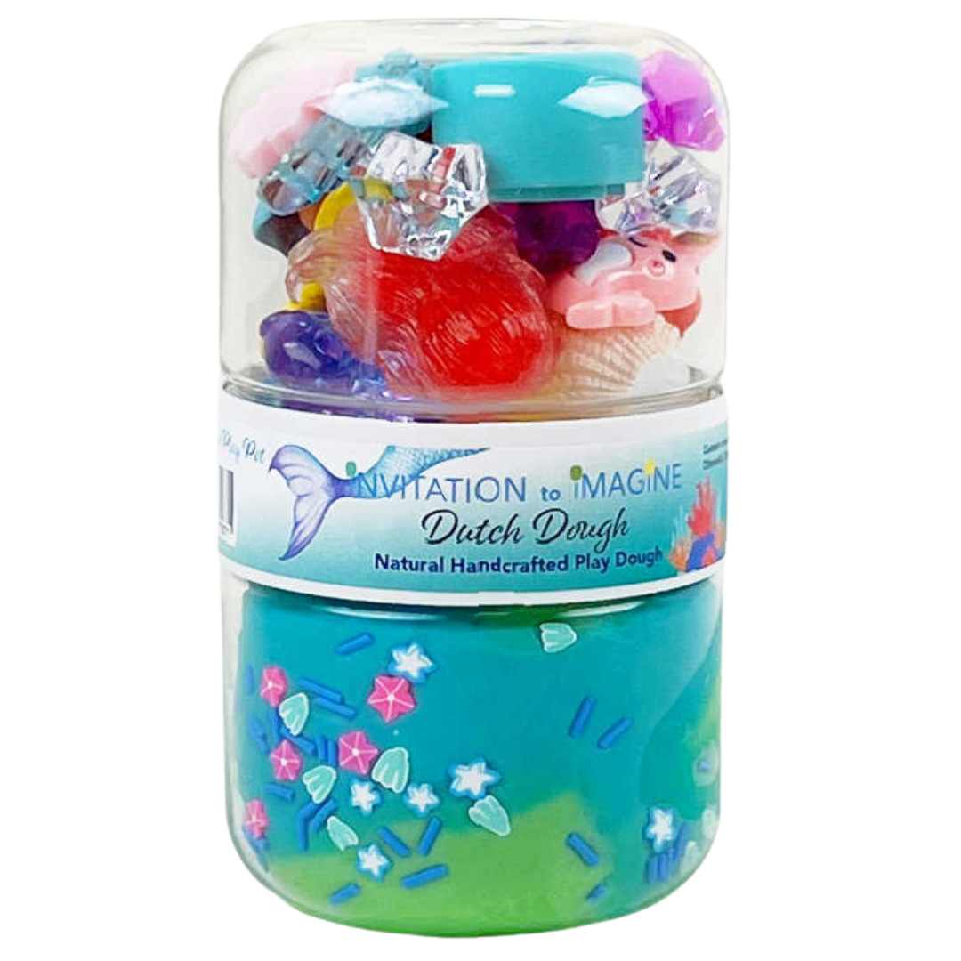 invitation to imagine speelklei play pot - mermaid, een transparante pot met blauwe klei en zeemeermin-accessoires.