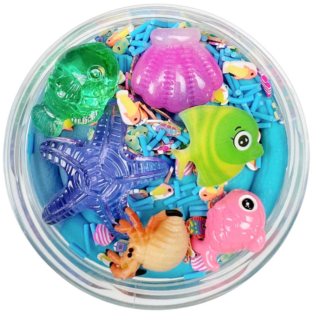 Invitation to imagine speelklei surprise pot met blauwe klei en diverse plastic zeedieren en sprinkles.