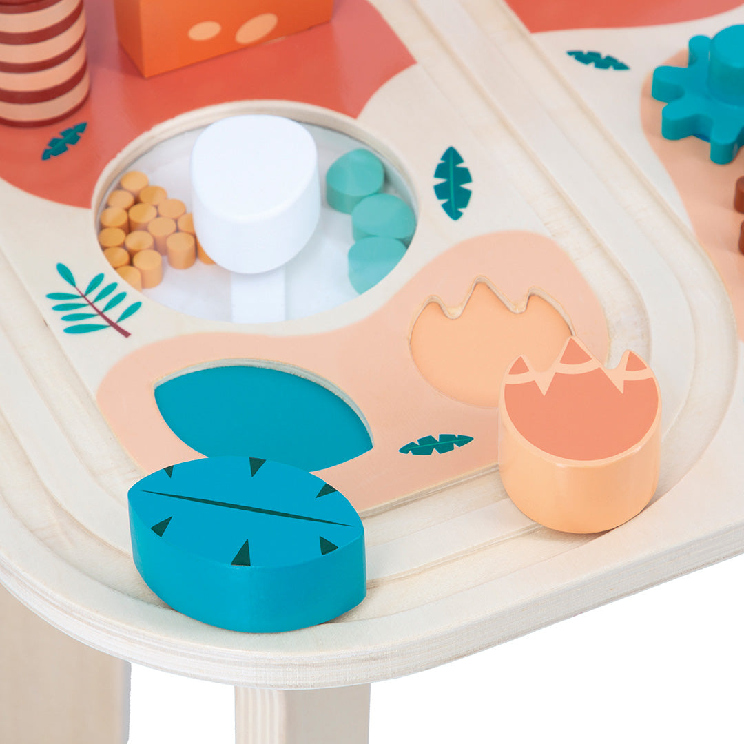 Detail van de Janod houten activiteiten speeltafel dino met een spoorbaan en diverse vormen om te sorteren.