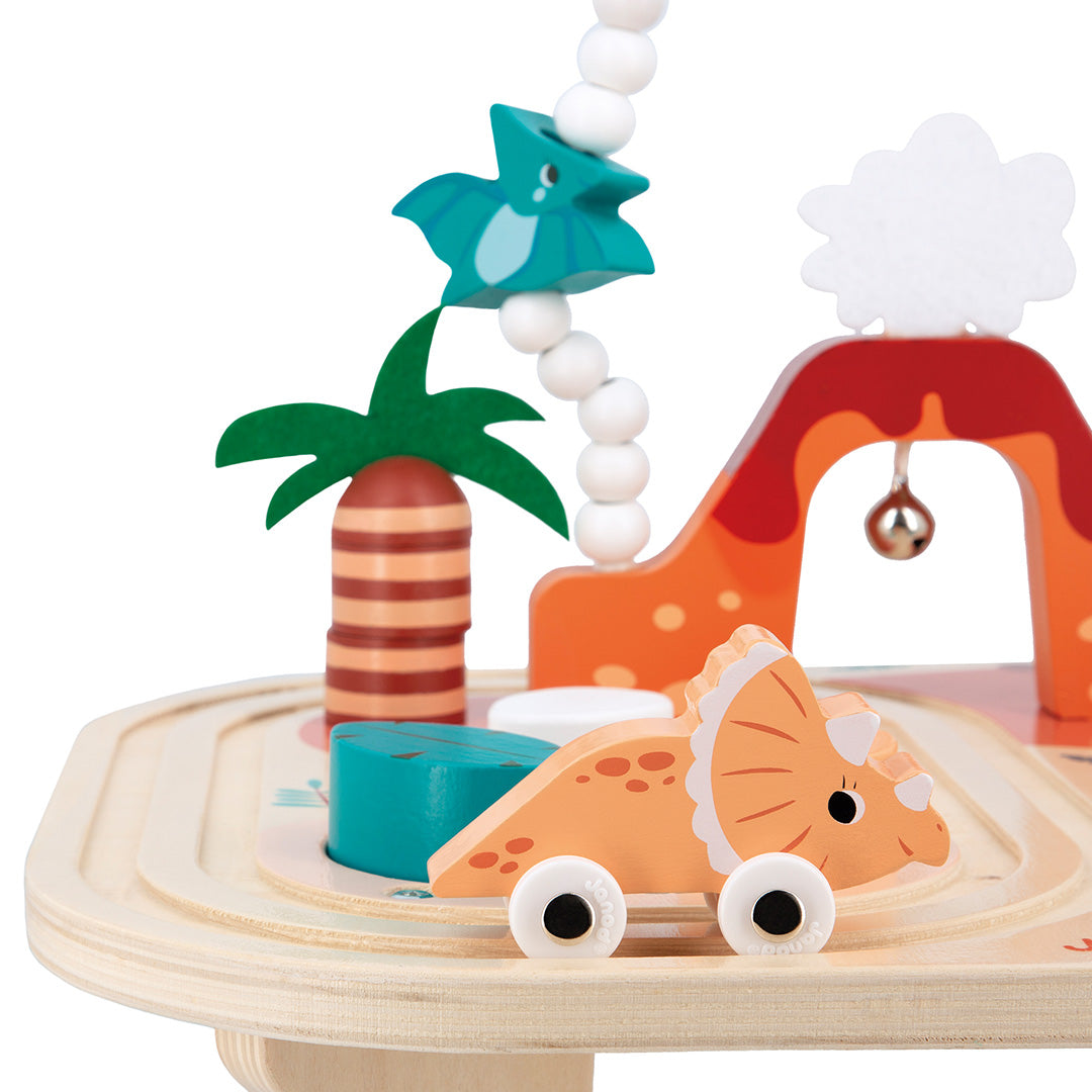 Detail van de Janod houten activiteiten speeltafel dino met een oranje dinosaurus autootje en een palmboom.