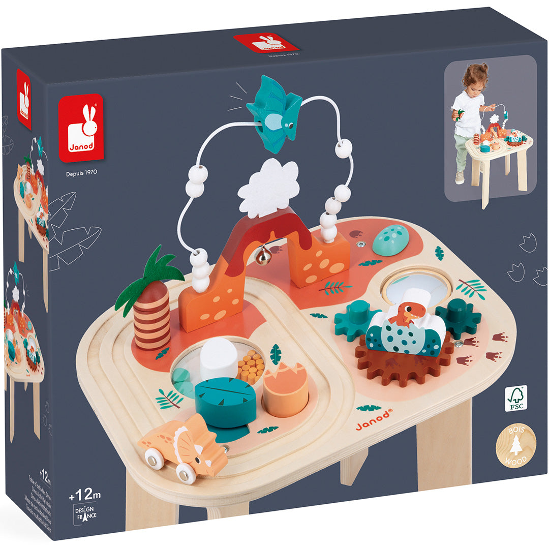 De verpakking van de Janod houten activiteiten speeltafel dino met een afbeelding van het speelgoed en een spelend kind.
