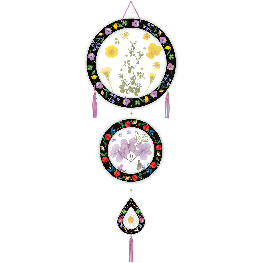 Een verticale hangdecoratie van geperste bloemen in drie ronde, versierde frames.