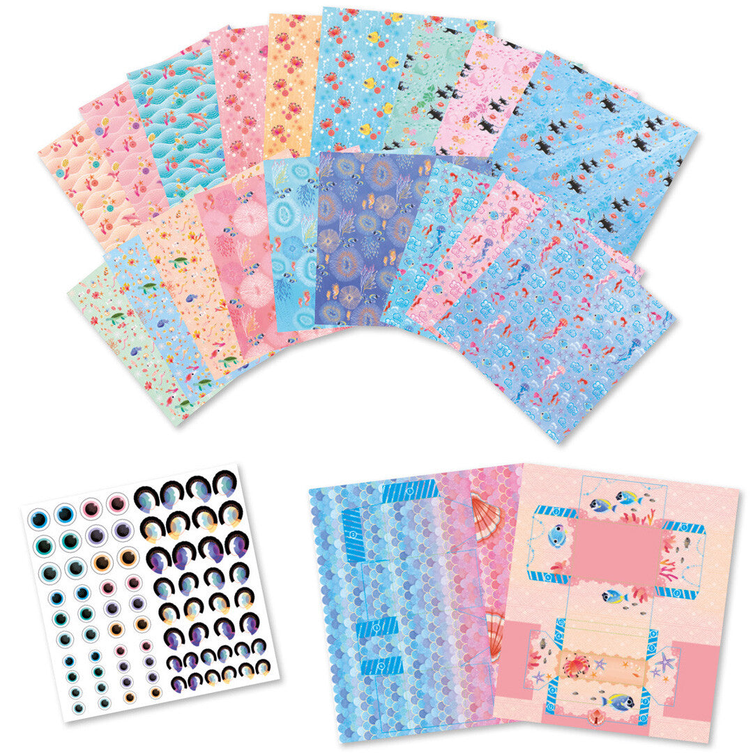Diverse vellen met zeedierenpatronen, stickervellen met ogen en voorgesneden doosjes voor de Janod Magic Ocean origami knutselset.