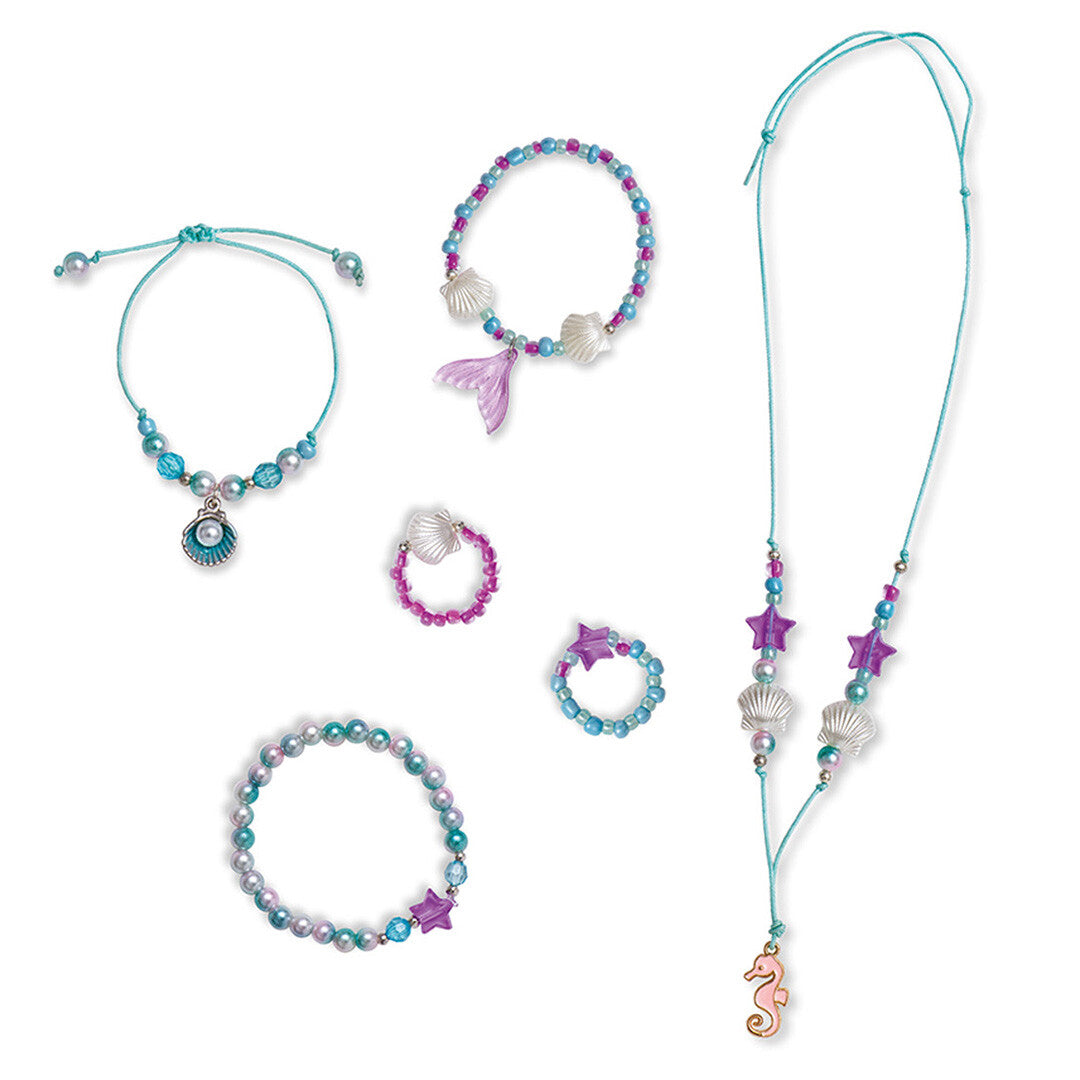 Overzicht van zes gemaakte sieraden met zeethema, waaronder armbanden, ringen en een ketting.