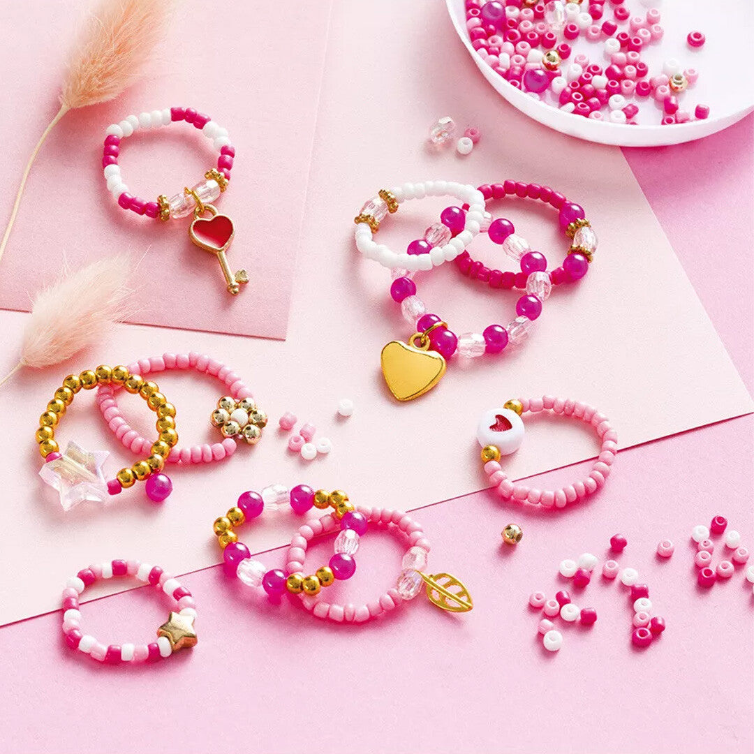Diverse roze, witte en gouden parelringen met hartjes en sterren, gemaakt met de sieradenkit.
