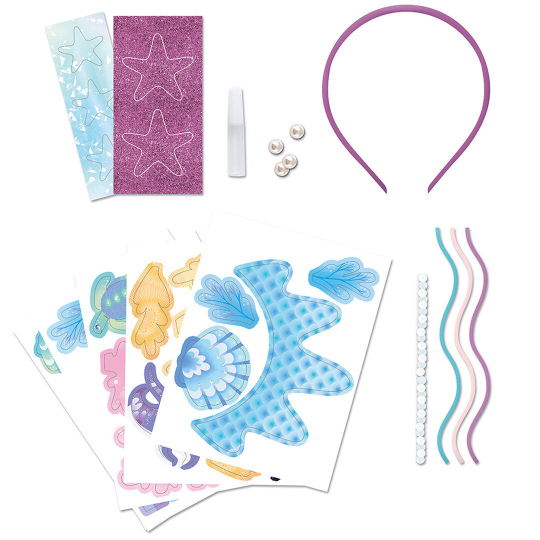 Alle onderdelen van de Janod 'Magic Ocean' knutselset voor een tiara, uitgestald op een witte achtergrond.