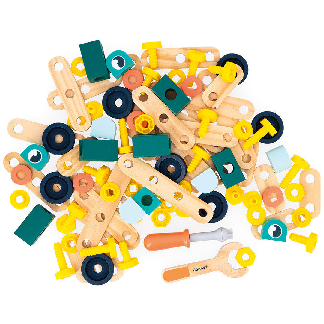 Een verzameling losse houten en plastic onderdelen van de Janod bouwset, inclusief een schroevendraaier en moersleutel.