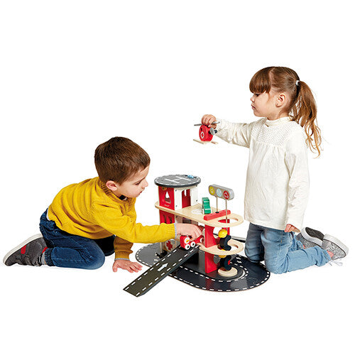 Twee kinderen spelen samen met de Janod houten brandweerkazerne speelset.