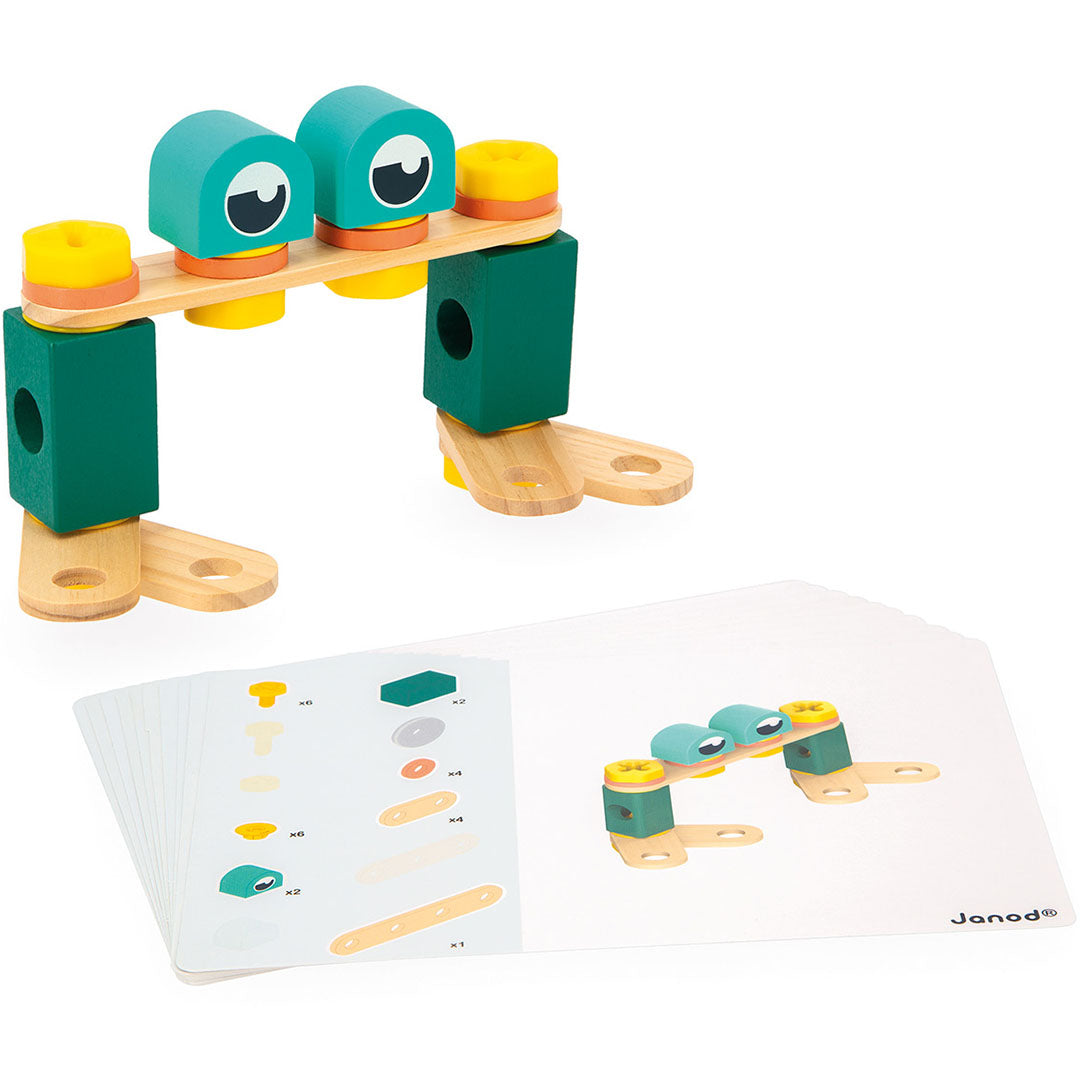 Een deels gemonteerde constructie van de Janod Brico'Kids houten bouwset met instructiekaarten ernaast.