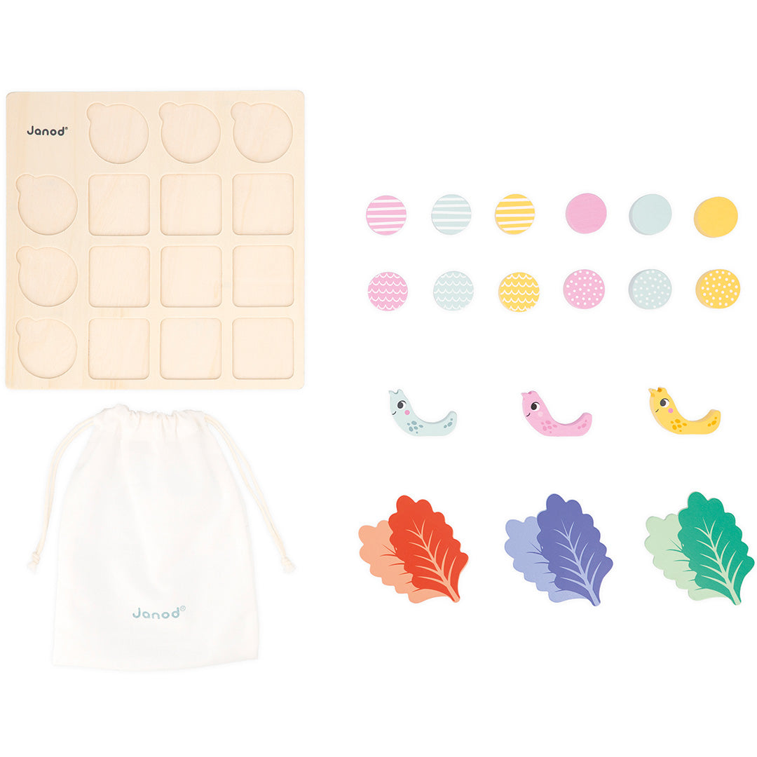 Alle onderdelen van het Janod educatieve spel, inclusief houten bord, patroontegels, slakken en een katoenen zakje.