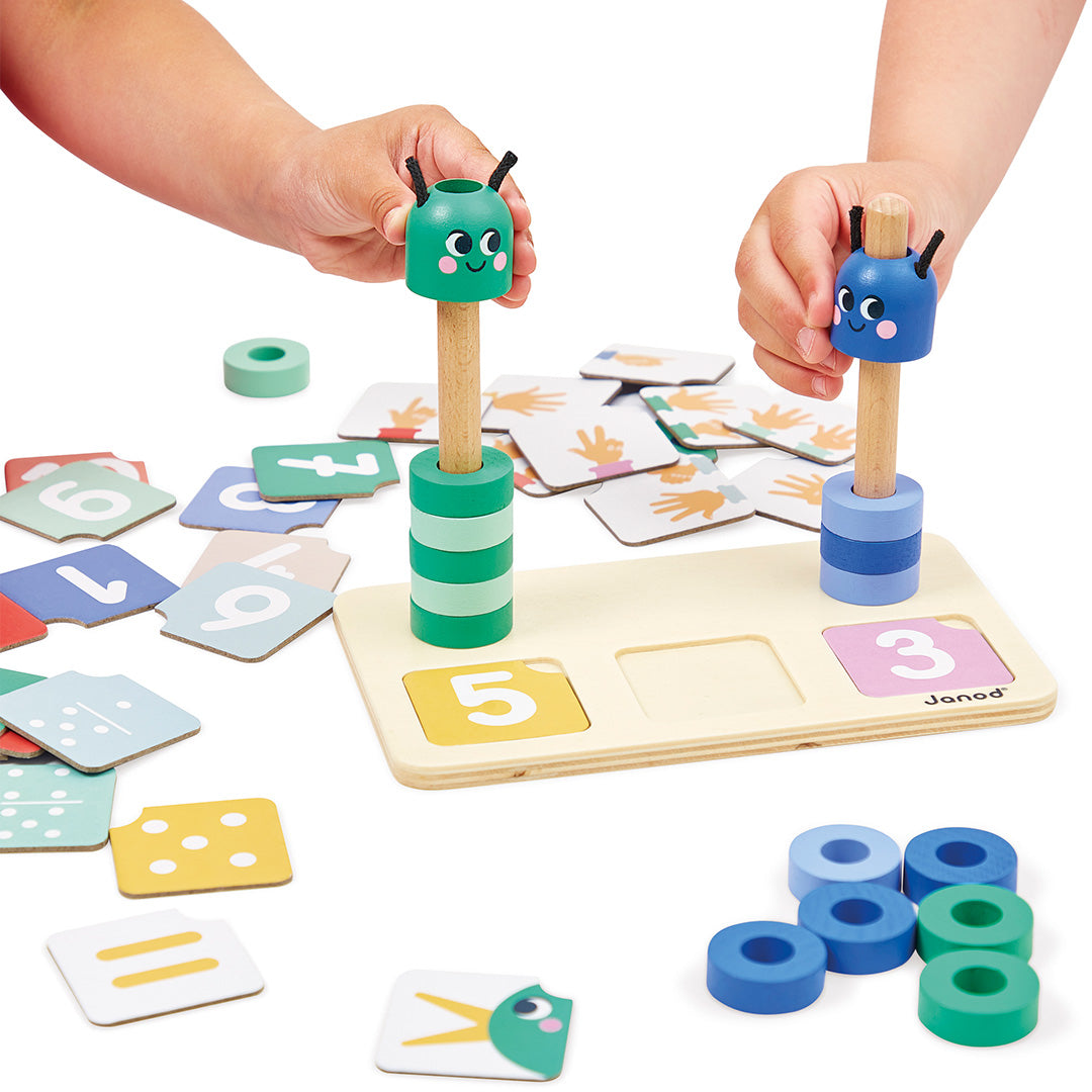 Kinderhanden spelen met het Janod houten sorteer- en stapelspeelgoed met rupsen en cijferkaarten.