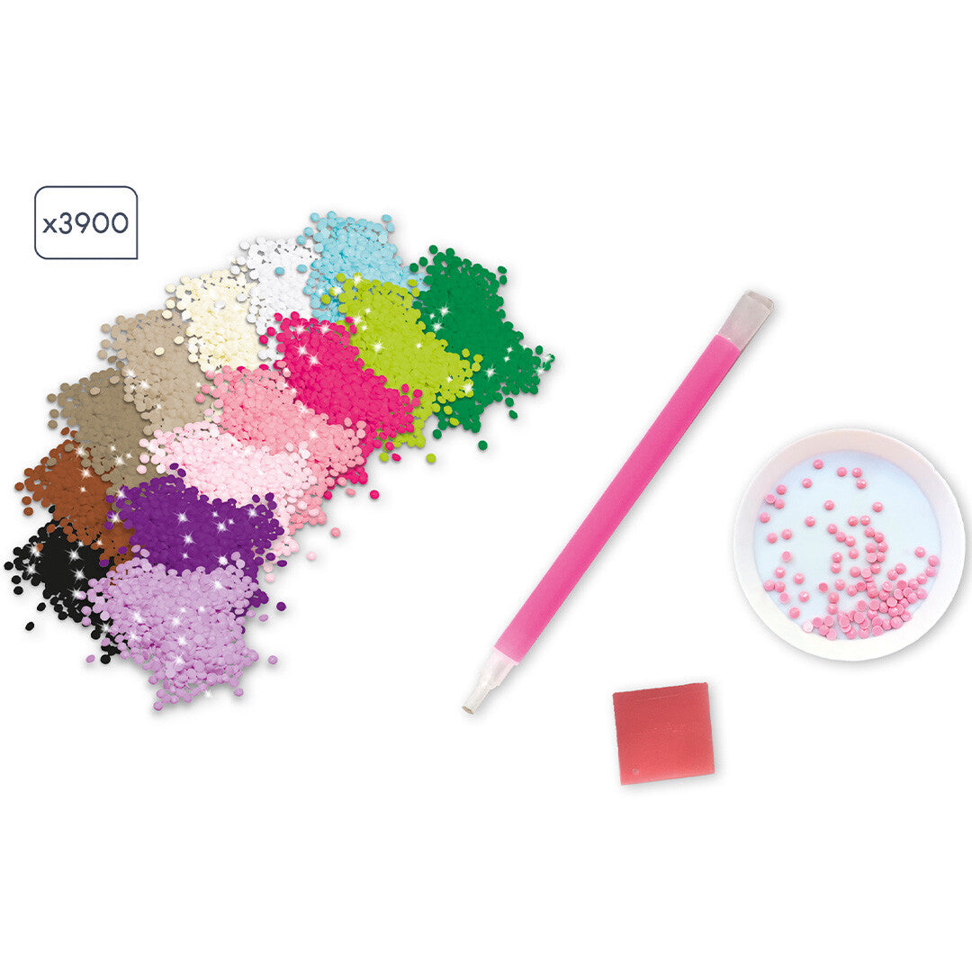 De onderdelen van de diamond painting set, met gekleurde diamanten, een roze pen en een schaaltje.