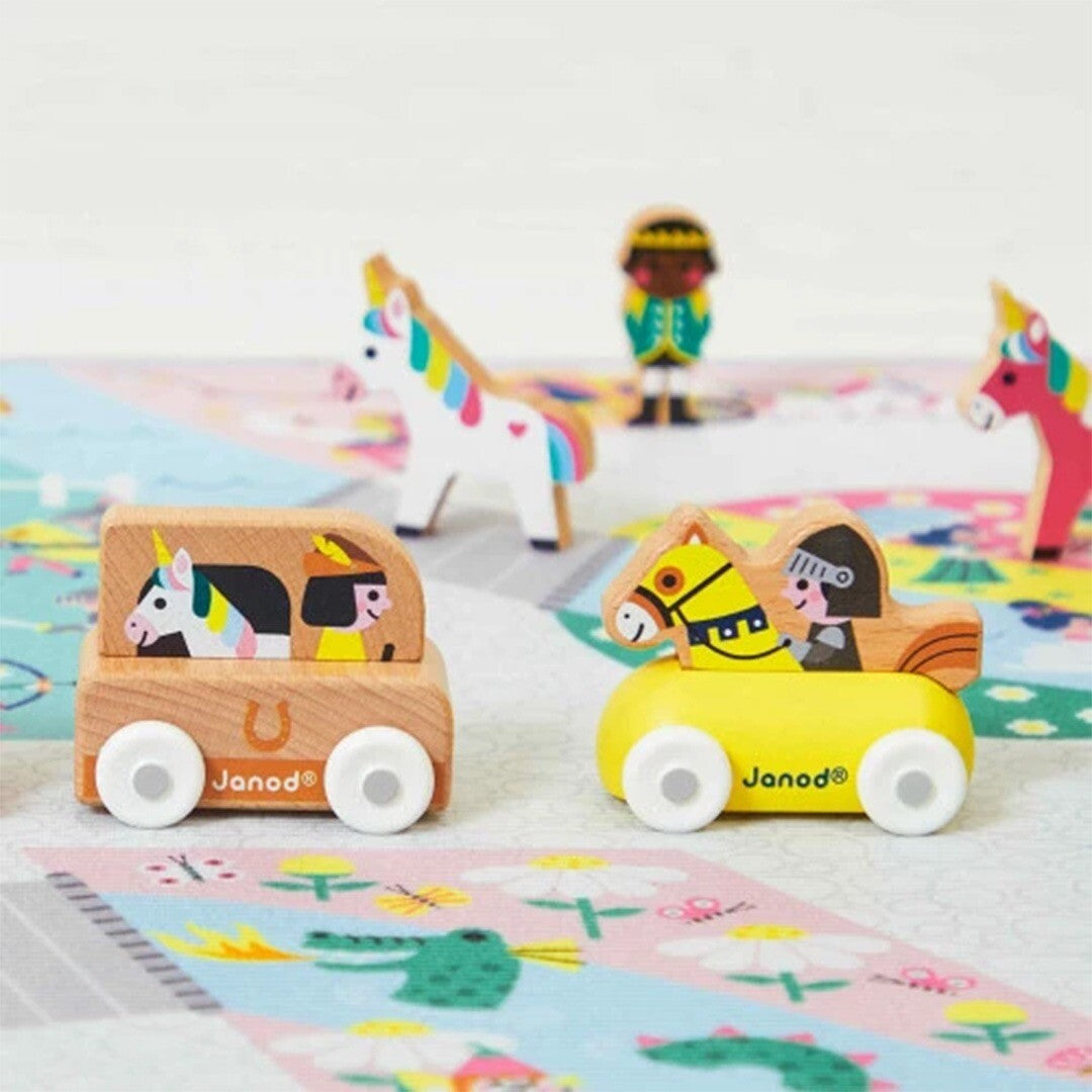 Janod houten speelgoedauto's en figuren op een speelmat.