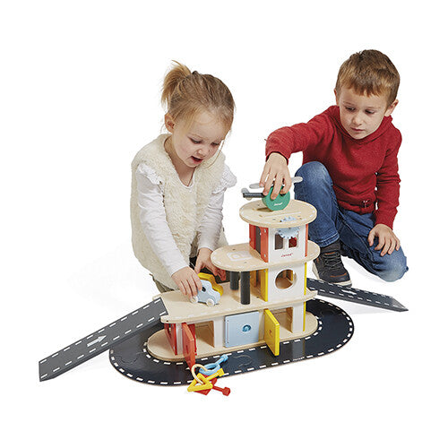 Twee kinderen spelen met de Janod houten garage speelset.
