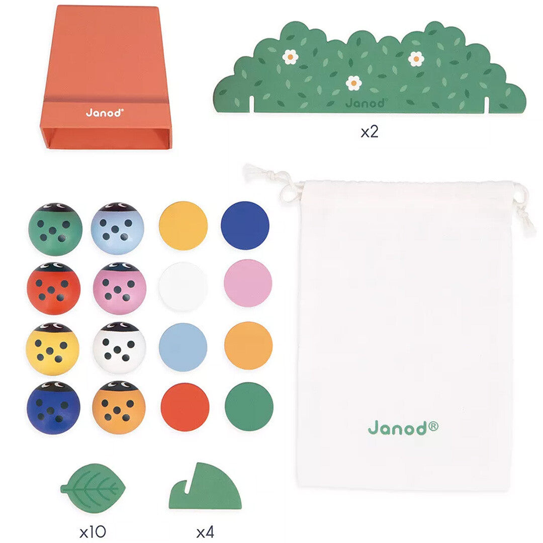 Alle onderdelen van het Janod houten geheugenspel met lieveheersbeestjes, inclusief de doos, struiken, lieveheersbeestjes en gekleurde schijven.