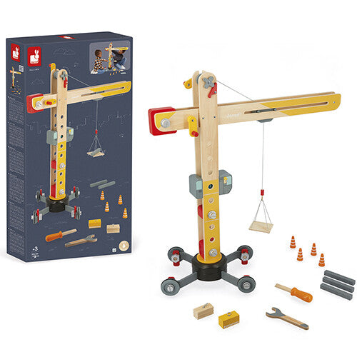 De verpakking van de Janod houten hijskraan naast het uitgestalde speelgoed.