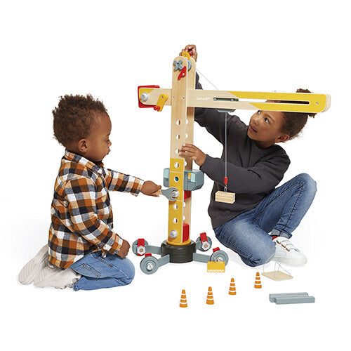 Twee kinderen spelen samen met de Janod houten hijskraan, waarbij een kind de kraan bedient.