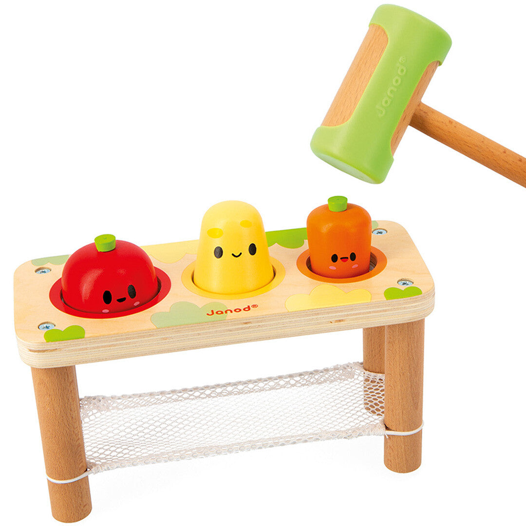 Janod hamerbank babyspeelgoed met groentefiguren erin, waarbij een hamer op het gele aardappelvormige figuur slaat.