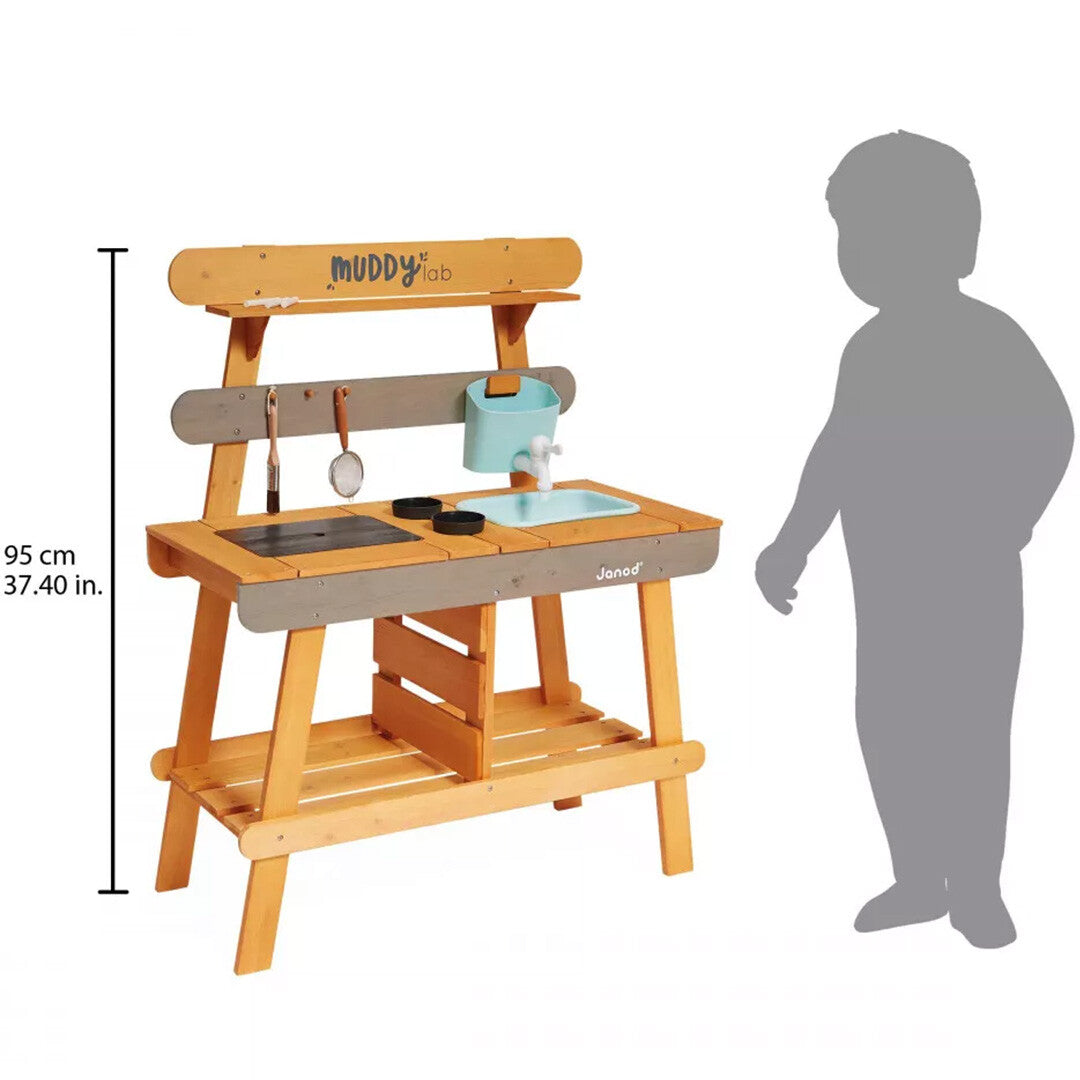 Janod houten kinder buitenkeuken met een silhouet van een kind ernaast voor schaal, met een hoogte van 95 cm.