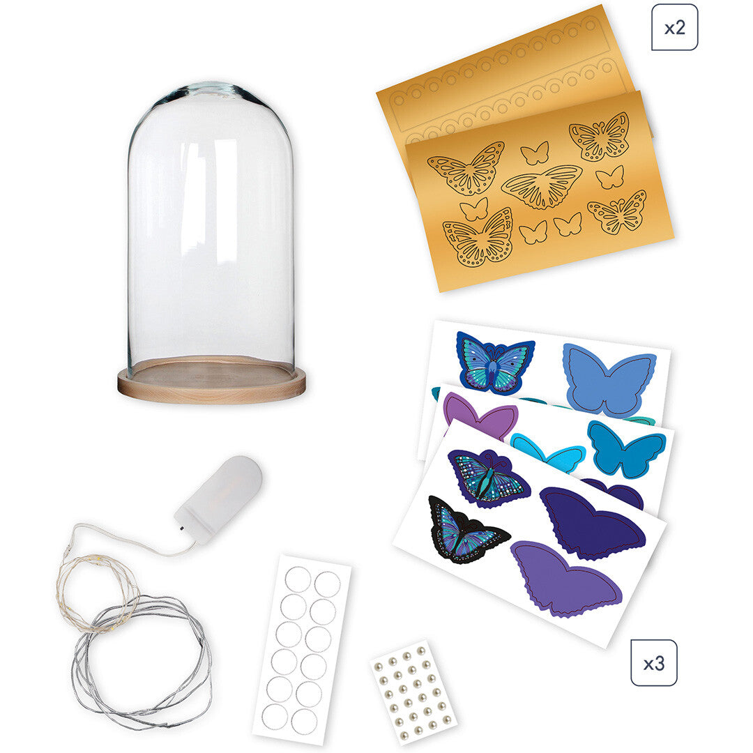 Alle onderdelen van de Janod knutselset voor een vlinder stolp, inclusief glas, houten basis, papieren vlinders en LED-verlichting.