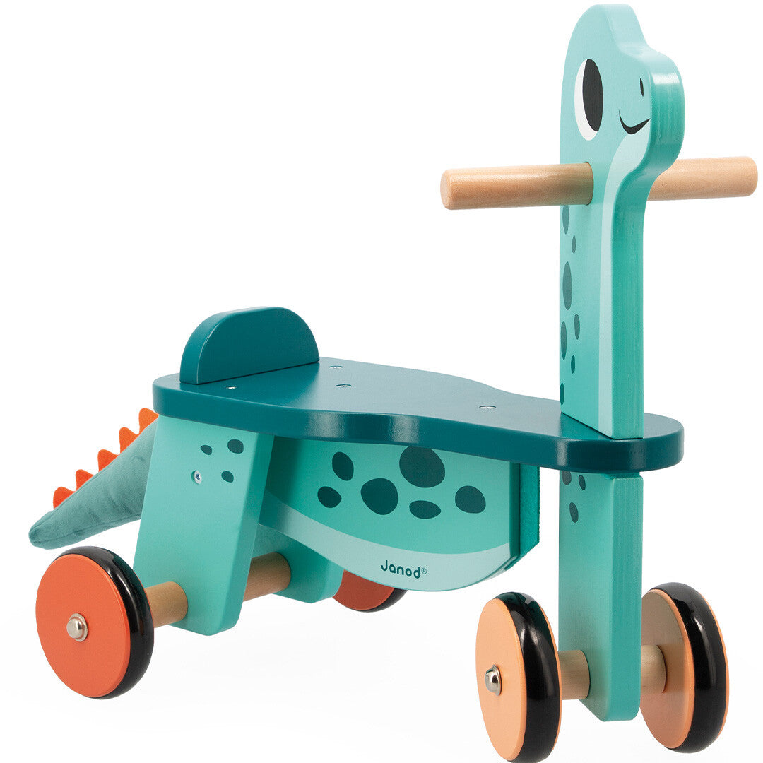 Janod houten loopfiets Portosaurus, een blauwe dinosaurus met vier oranje wielen.