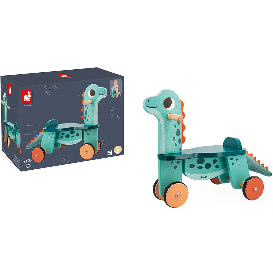 De Janod houten loopfiets Portosaurus staat naast de productverpakking.