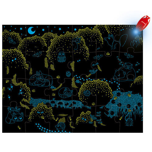 De magische puzzel 'Het bos' in het donker, met oplichtende dieren en planten, verlicht door de rode magische lamp.