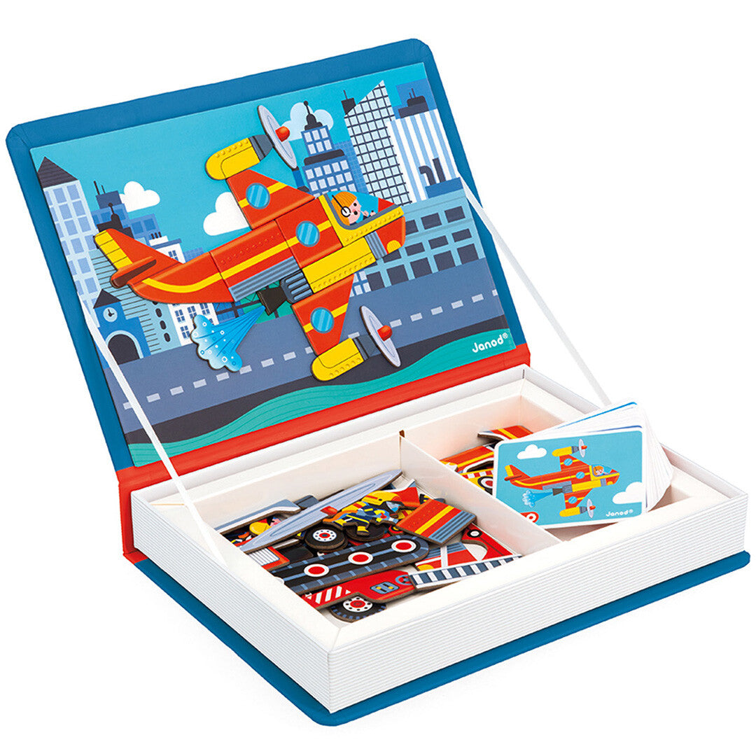 Het Janod magneetboek brandweer open, met een geel-rood vliegtuig van magnetische stukken op de stadsachtergrond.