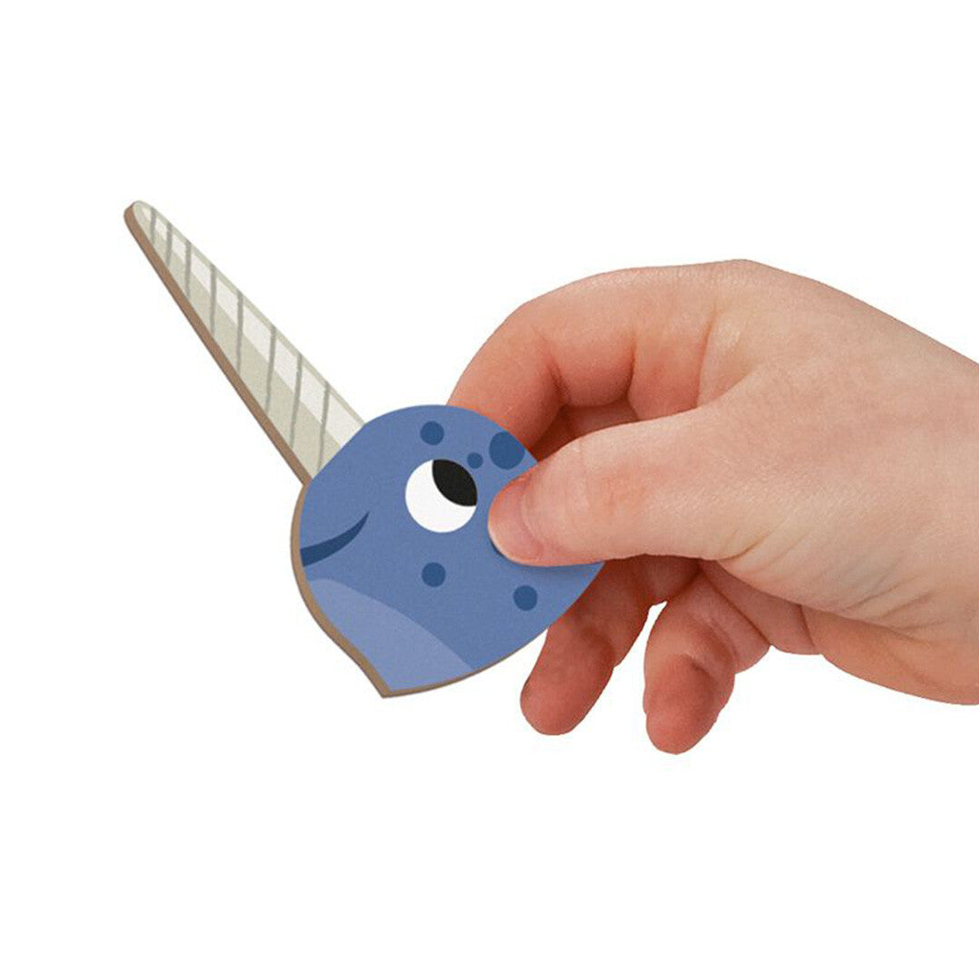 Een kinderhand houdt een Janod narwal magneetstuk vast.