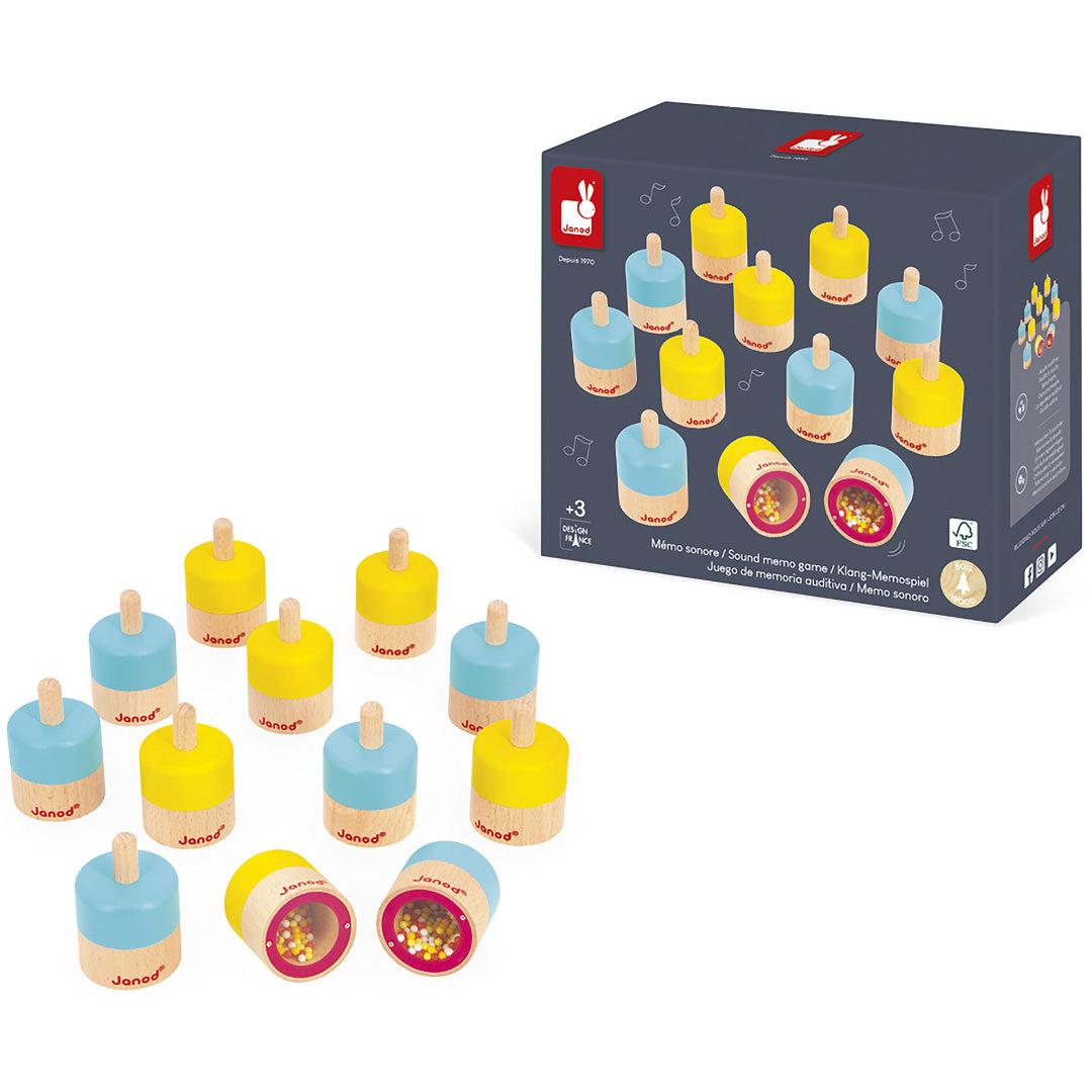 De verpakking van het Janod houten geluiden memory spel met enkele speelstukken ernaast.